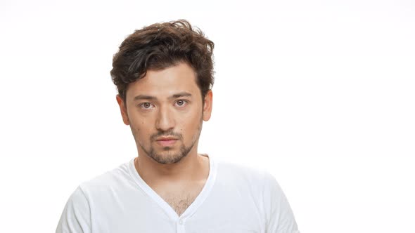 Nervous Young Handsome Man Looking at Camera Over White Background