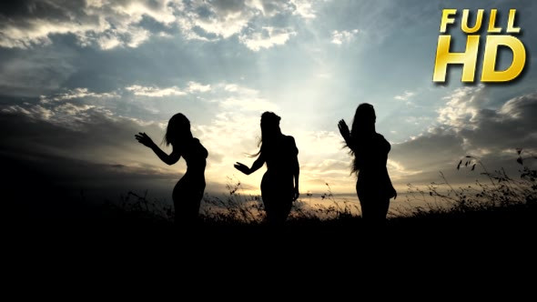 Silhouettes Against Sunset Of Three Young Slender