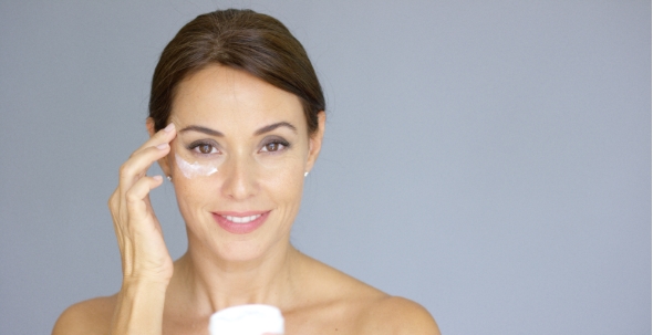 Beautiful Young Woman Applying Face Cream