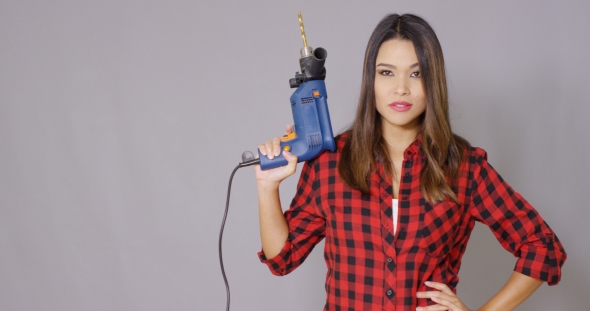 Capable Attractive Young Woman Holding a Drill