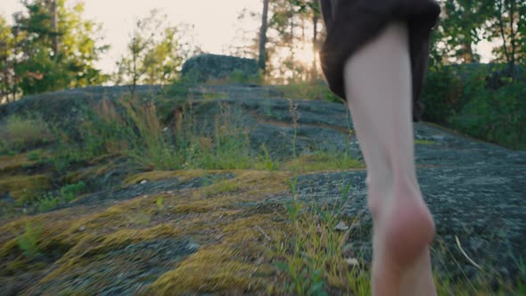 Barefoot Legs of Man Running on Rock Pathway Against Forest
