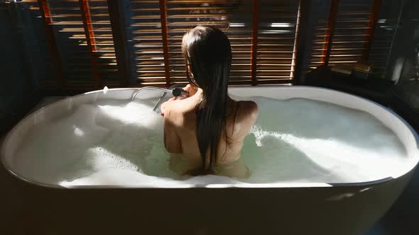Sexy Woman Taking Bathtub with Bubbles at Home Relaxing and Spa in Luxury Hotel