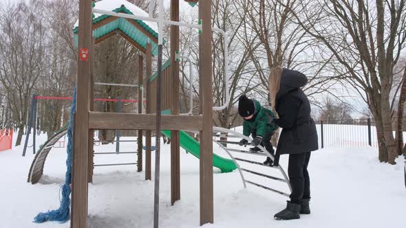 Blond Mommy Helps the Child to Climb the Hill