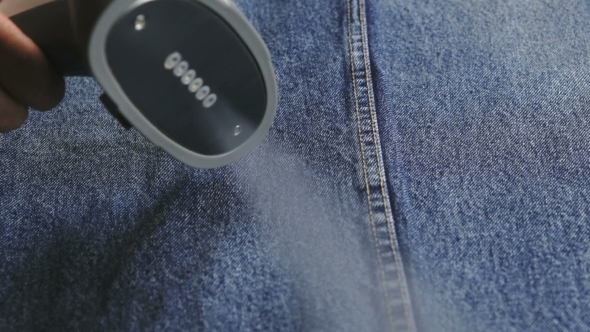 Woman Steaming Denim Fabric On Ironing Table