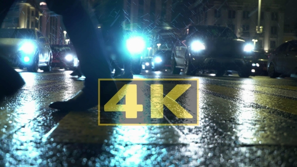 Pedestrians And Falling Snow On Wet Crosswalk In Winter. Snowflakes In Headlight