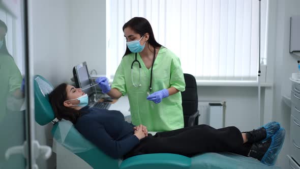 Side View Young Woman Lying on Examination Couch As Nurse Taking Covid19 Virus Analysis By Nasal