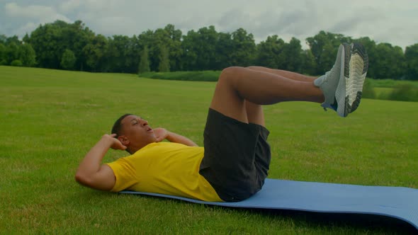 Motivated Athletic Black Man Doing Crunches Exercise in Nature