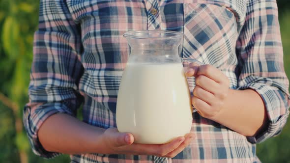 A Farmer Holds a Jug of Milk