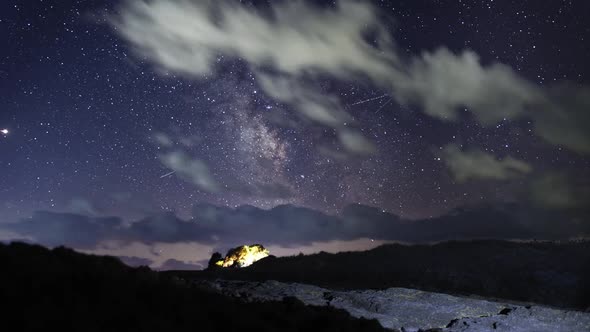 Planet Mars and the Milky Way Galaxy on Dark Sky over Rocks and Bushes Night Time Lapse