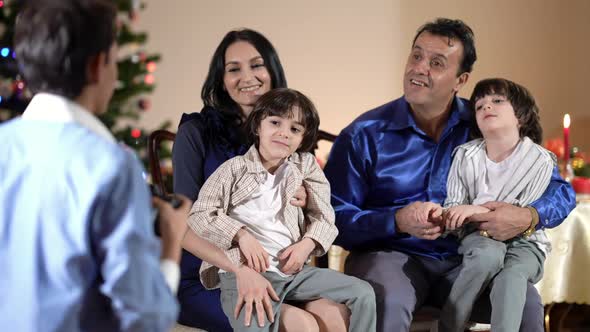 Caucasian Mother and Middle Eastern Father with Twin Sons in Living Room on Christmas As Teenage Boy