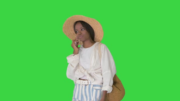 Pretty Young African American Woman in a Straw Hat Talking on Her Phone on a Green Screen, Chroma