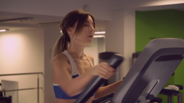 Caucasian Woman Trains On Cardio Machine.