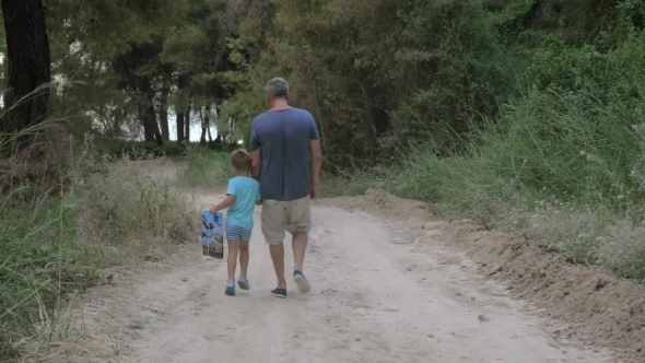 Child Walking Through The Wood With Grandpa