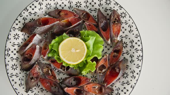 Seafood Salted Juicy Pieces of Fish with Caviar with Lettuce and Lemon on a White Plate Closeup