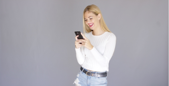 Trendy Young Blond Woman Checking Her Mobile