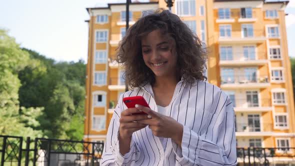 Hispanic Young Woman Checking Social Media on Her Smartphone