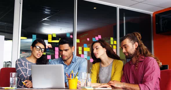 Executives having discussion over laptop