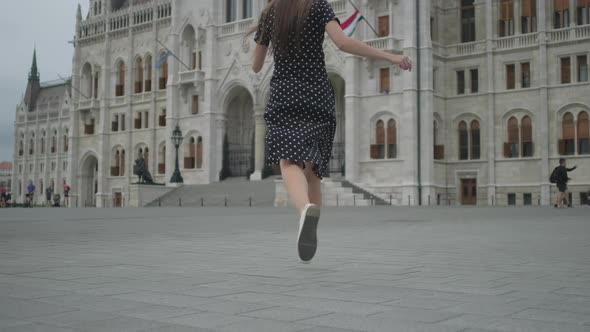 Excited Girl Running to Parliament of Budapest Hungary