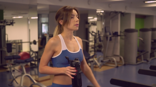 Sportswoman Going On Cardio Machines Drinks Special Drink.