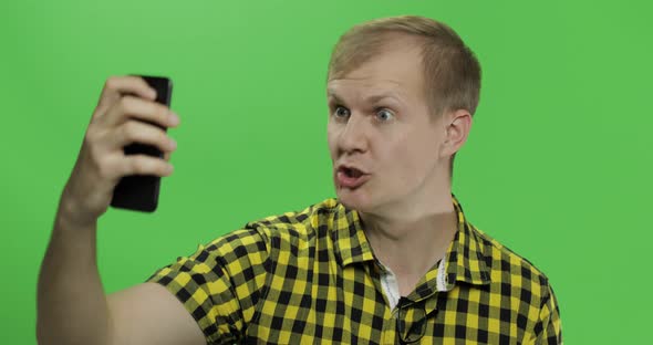 Caucasian Young Man in Yellow Shirt Taking Nice Selfies on the Smartphone