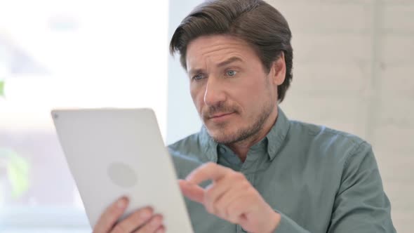 Portrait of Middle Aged Man using Digital Tablet