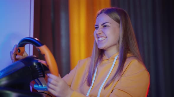 Gamer girl playing video games. Woman having fun while driving on car racing simulator