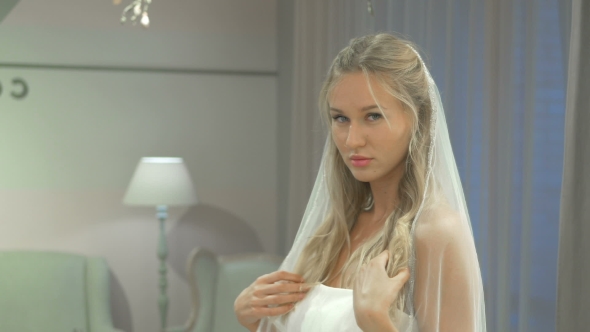 Blonde In Dress Posing On Camera In Wedding Salon
