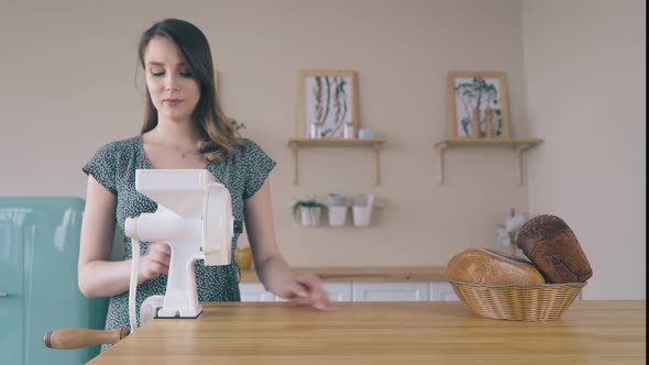 Woman Installs Handle To Domestic Flour Mill on Wooden Table