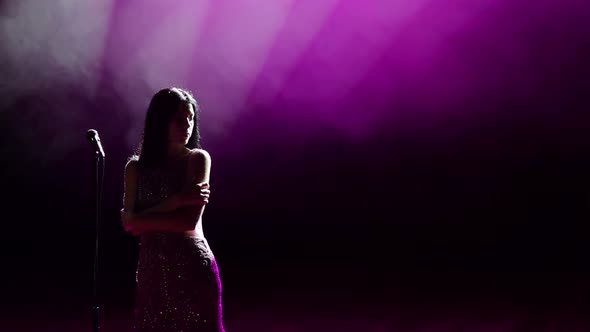 Beautiful Girl with Microphone on an Empty Stage