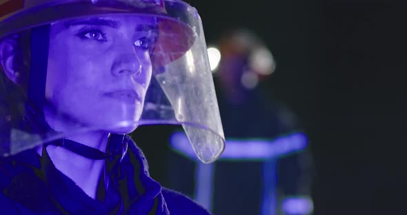 Closeup Portrait Female and Male Fireman Team in Fireproof Equipment Near Fire Truck Flashing Color