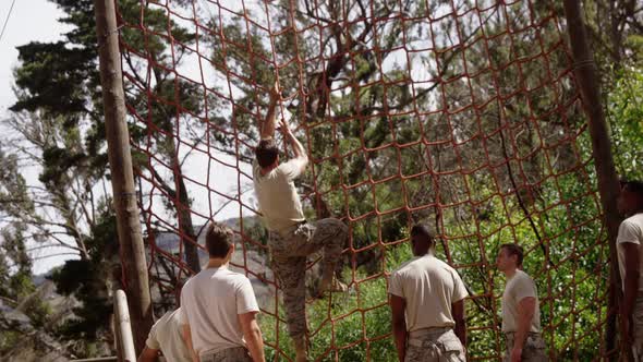 Military troops climbing a net during obstacle course 4k