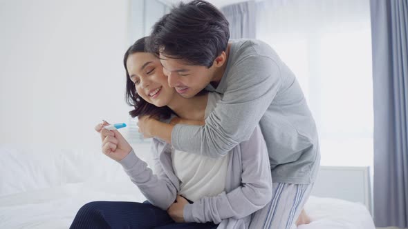 Asian young woman feel happy and excited after look at positive pregnancy test with husband.