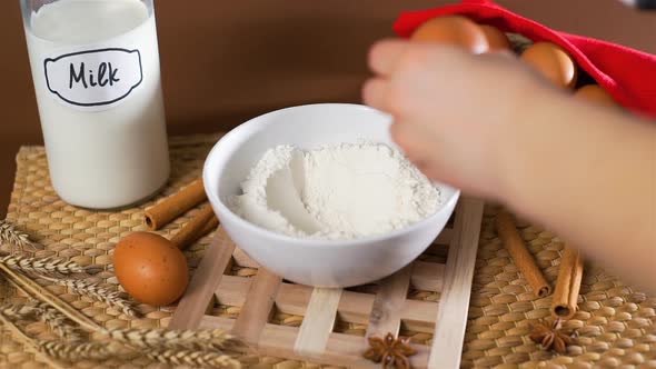 Closeup of Breaking Egg Into a Flour