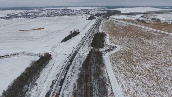 Aerial View Of Cargo Train Delivering Goods, Fuel, Petrolium In Winter.