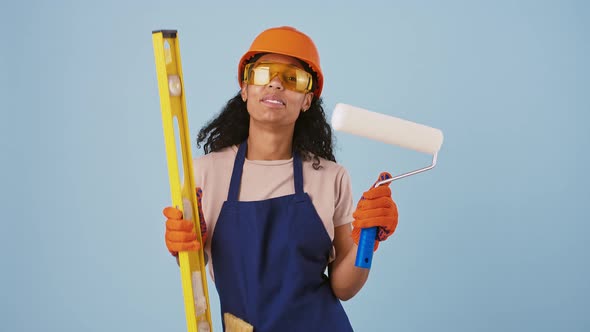 Darkskinned Female Worker in Hard Hat Protective Goggles and Gloves