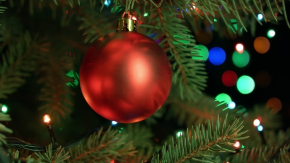 Christmas Tree Ball On Background Of Blurred Fairy Lights Garland