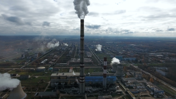 Ecology Pollution. Industrial Factory Pollutes The Environment Blowing Smoke From Pipes.
