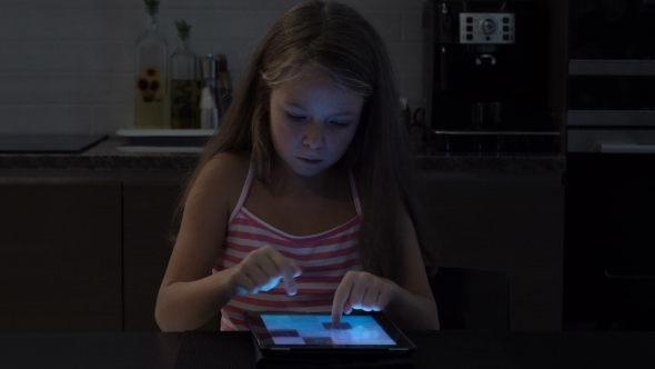 Little Girl Playing a Game on Tablet at Home