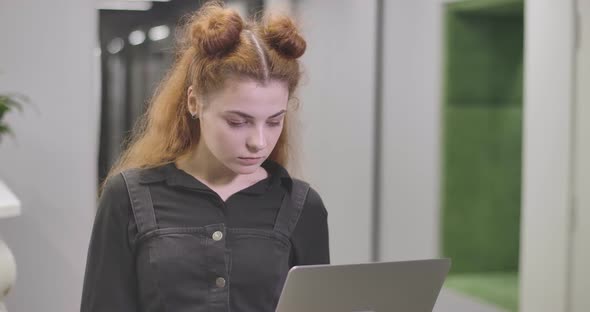 Close-up of Confident Redhead Caucasian Woman Typing on Laptop Keyboard, Looking at Camera and