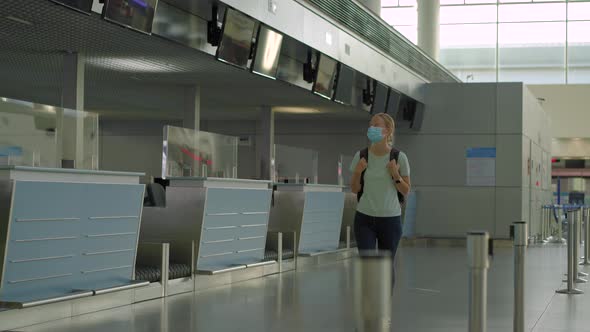 Woman in Mask at Empty Airport at Check in in Coronavirus Quarantine Isolation Returning Home Flight