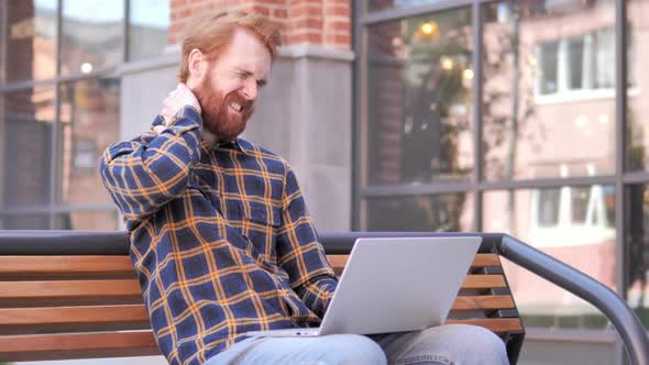 Redhead Beard Young Man with Neck Pain Using Laptop Outdoor