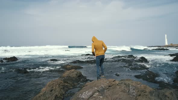 Tourist Man in Yellow Sweatshirt Walks on Volcanic Beach in North of Canary Island Tenerife