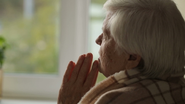 Old Woman Praying In a Fron Of Window
