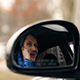 Young Man Sitting in a Car and Talking on the Phone, Shot Through the Mirror Car - VideoHive Item for Sale