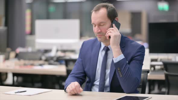 Businessman Talking on Smartphone in Office