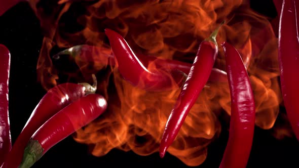 Super Slow Motion Shot of Flying Red Chilli Peppers in the Fire