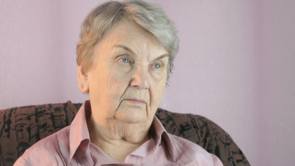 Elderly Woman Looks in the Direction Indoors