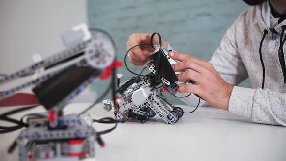 assembling a model of robotics from plastic toy blocks