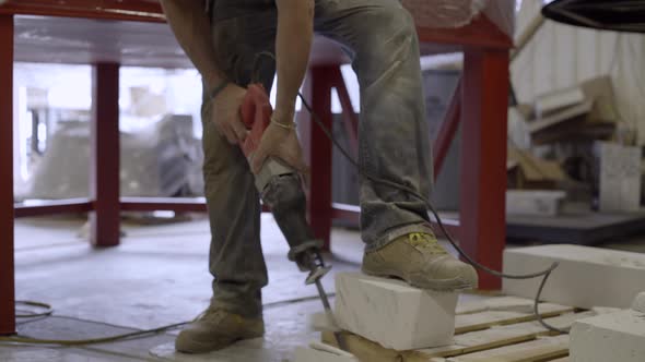 Worker cutting a concrete block with sawzall