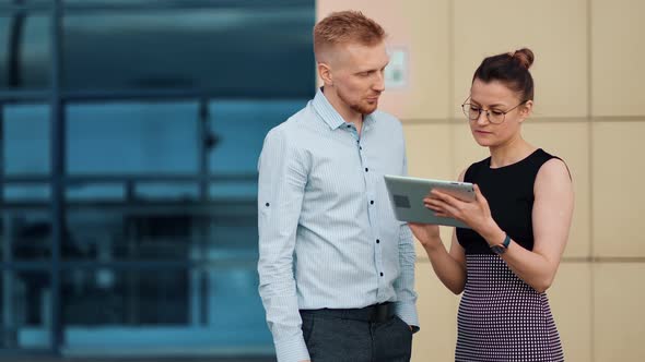 Confident Businessman and Businesswoman Working As Team Using Tablet Pc Outdoor